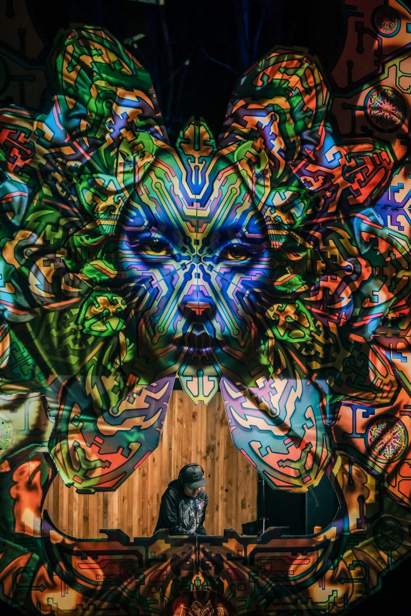 DJ performing beneath intricate stage artwork