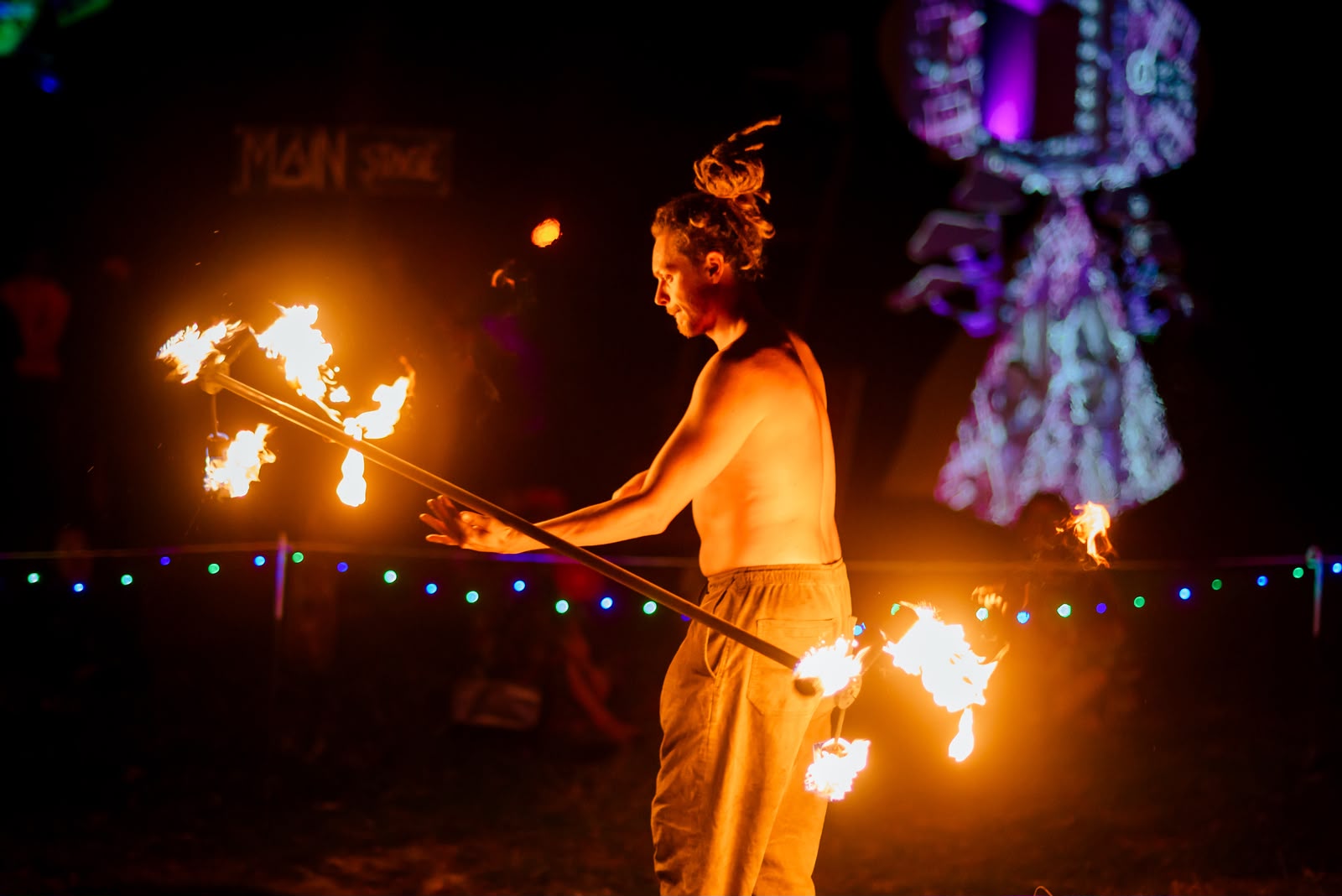 A performer spinning a flaming staff